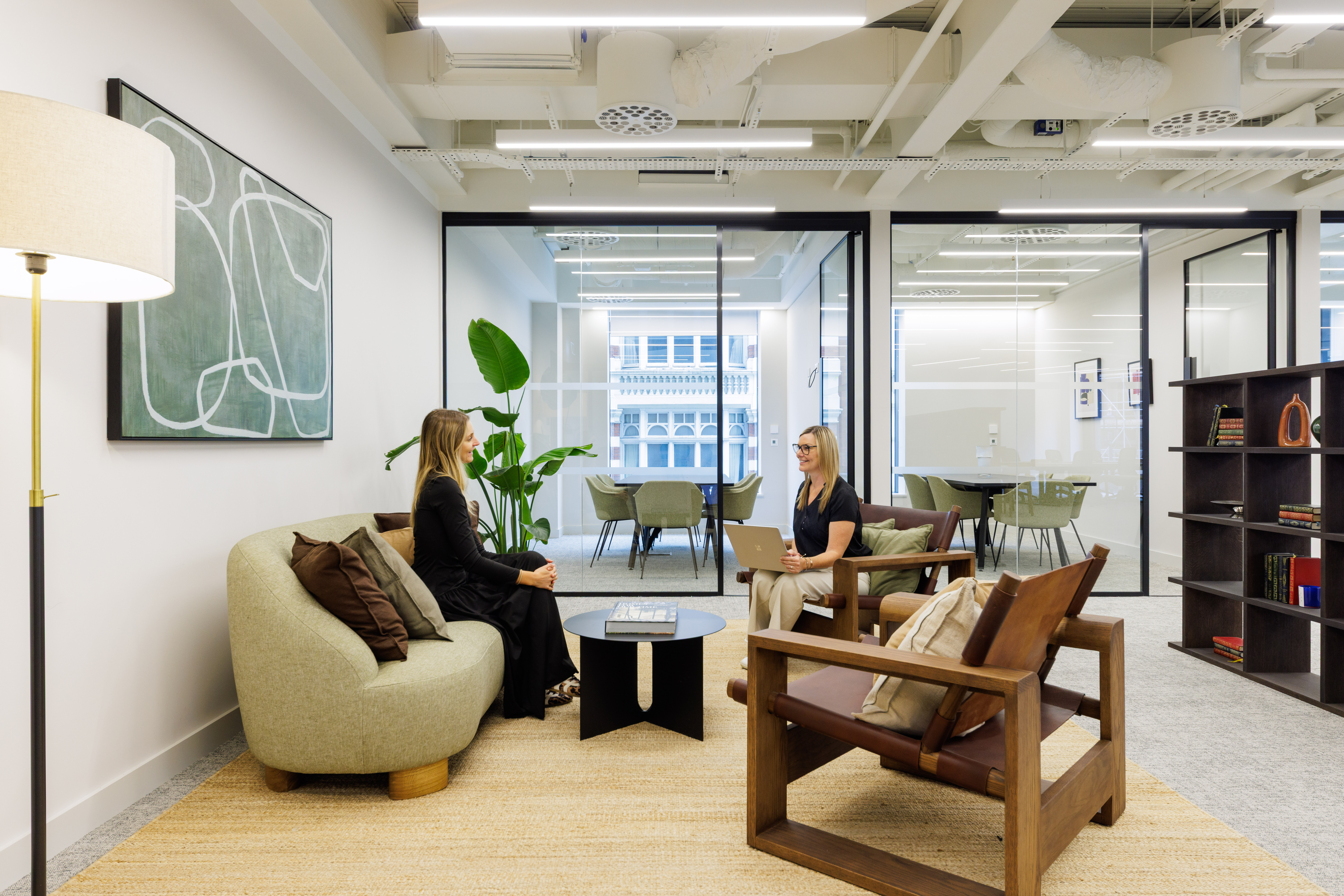 Professionals collaborating in a modern meeting room with contemporary artwork and integrated technology.