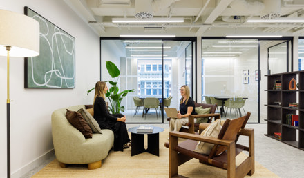 Professionals collaborating in a modern meeting room with contemporary artwork and integrated technology.