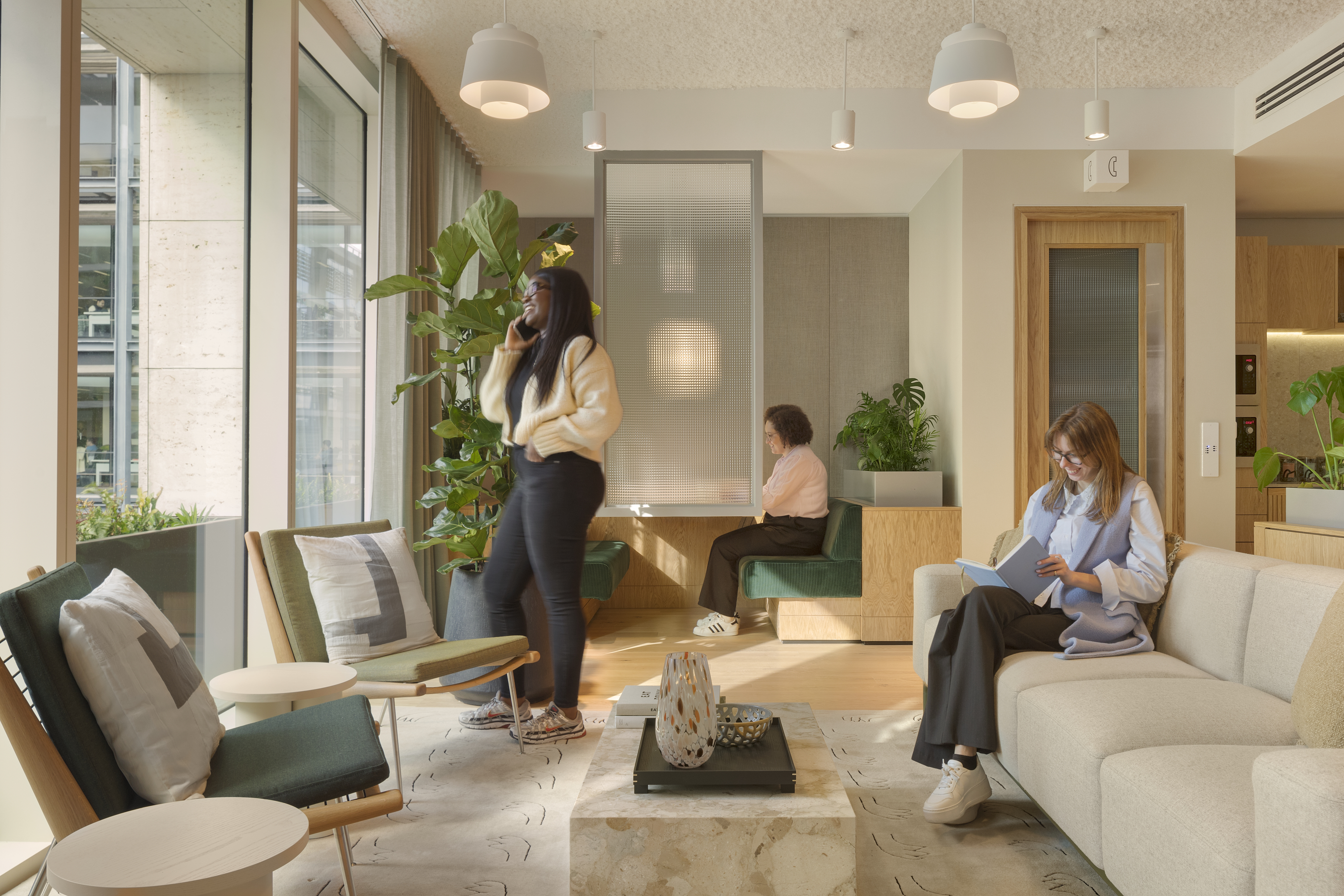Three members using separate areas of MYO's modern workspace featuring comfortable seating and contemporary design.