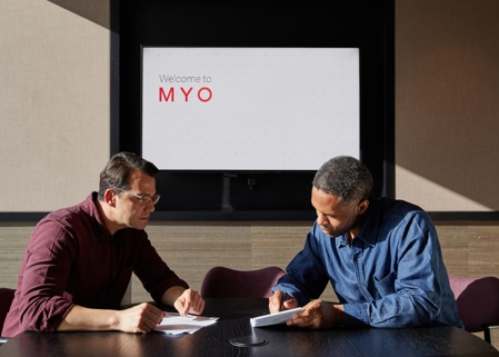 Two professionals meet in The Hub meeting room