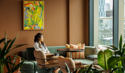 Professional relaxing in a comfortable lounge area at MYO King's Cross with soft seating, planting and views across the city.